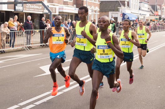 Marathon runners racing in a city street with visible spectators and buildings.