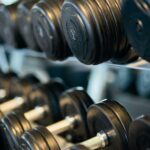 Close-up view of black dumbbells neatly arranged on a rack in a gym.