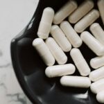A detailed shot of white capsules in a black bowl, highlighting healthcare concerns.