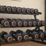 A neat arrangement of heavy dumbbells on a gym rack, ideal for workouts and strength training.